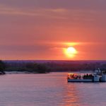 Pontoon boats on the Zambezi River at sunset in Livingstone, Zambia